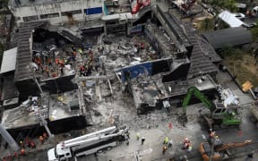AThis aerial view shows rescue teams working at the Jet Set nightclub a day after the collapse of its roof in Santo Domingo on April 9, 2025. Rescuers raced to find survivors among the rubble of the nightclub where at least 124 people, including a former Major League Baseball star, were killed when the roof collapsed. (Photo by Alfred DAVIES / AFP)