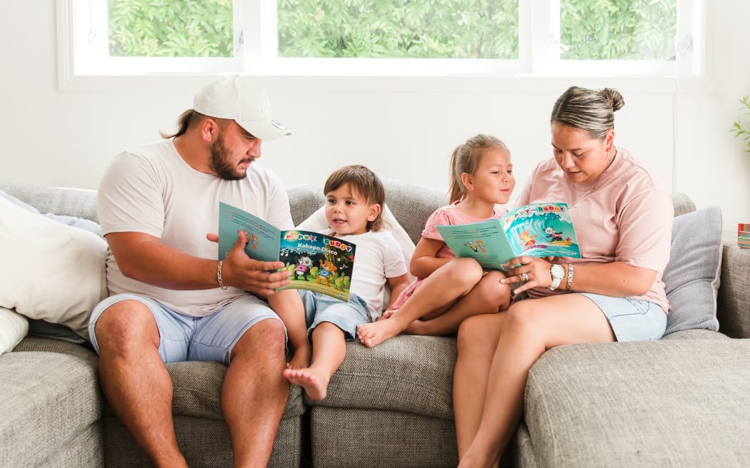 A whānau reading Poppy and Buddy books