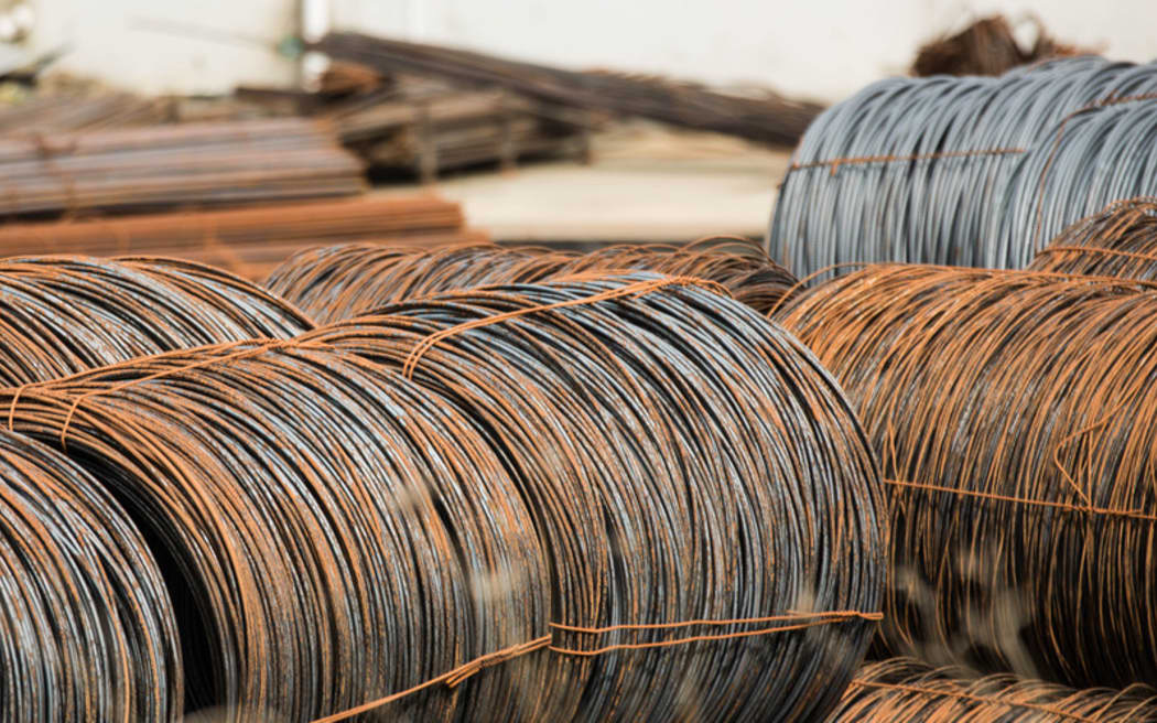 Steel sitting in a yard in an industrial area.