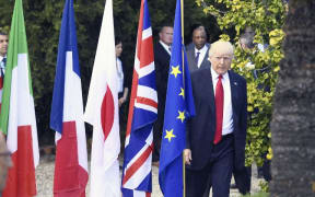 Donald Trump walks for a group photo after the Outreach Session during the G7 Summit.
