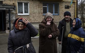 People cry outside their houses in Bucha, northwest of Kyiv, Ukraine, on 2 April, 2022. The liberated town's mayor said 280 people had been buried in a mass grave and that the town was littered with corpses following last month's invasion by Russia.