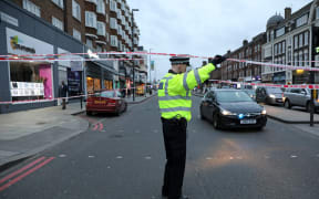 A police officer at a cordon on Streatham High Road, south London, after a man is shot dead by police following reports of a stabbing.