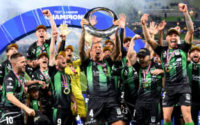Western United's players celebrate with the trophy after winning the A-League football grand final against Melbourne City in Melbourne on May 28, 2022. (Photo by William WEST / AFP) / -- IMAGE RESTRICTED TO EDITORIAL USE - STRICTLY NO COMMERCIAL USE --