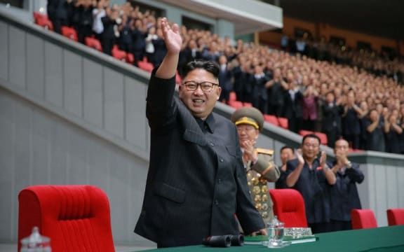 This August 28, 2016 picture released by North Korea's official Korean Central News Agency (KCNA)  Kim Jong-Un waving while attending a torchlight gala of members of the youth vanguard at the May Day Stadium.