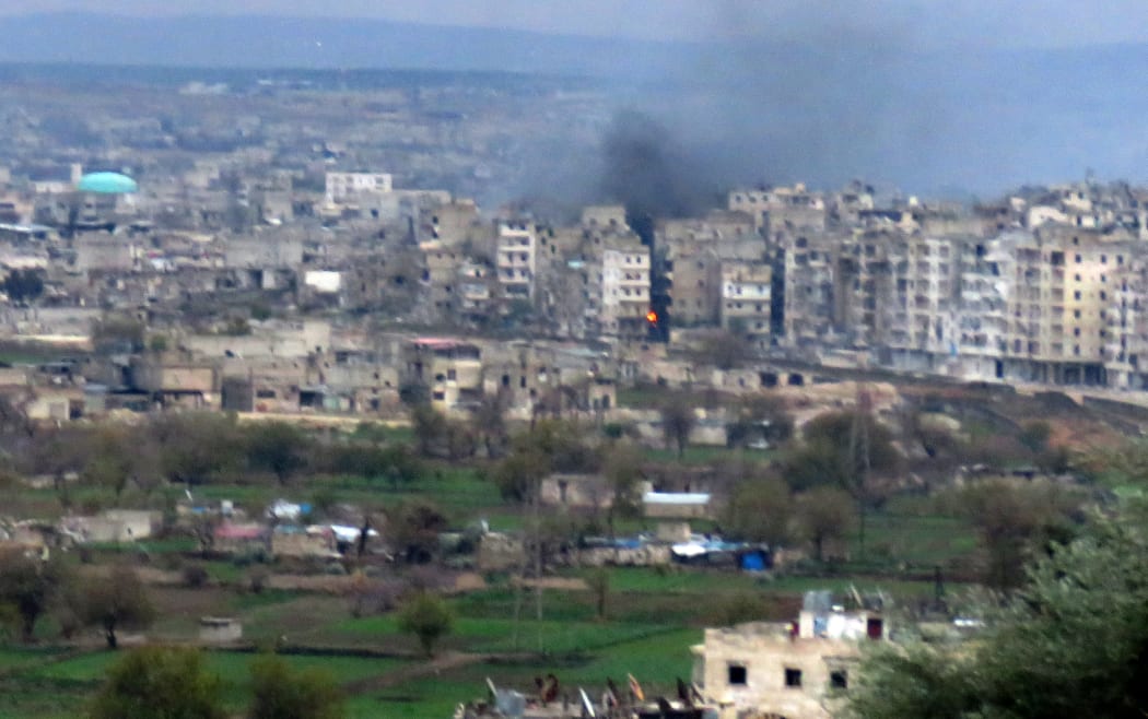 Fire rises from buildings in Aleppo's southeastern al-Zabdiya neighbourhood following government air strikes on 14 December, 2016.