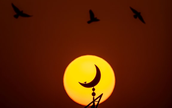 The sun sets behind the mosque outside the Khalifa Stadium in Doha, Qatar.