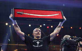 Oleksandr Usyk holds up Mazepa’s Sabre after his win over Tyson Fury for the WBA (Super), WBO and WBC world heavyweight titles on 22 December 2024.