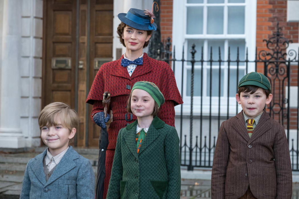 Left-right: Georgie (Joel Dawson), Annabel (Pixie Davies) and John (Nathanael Saleh) being nannied by Mary Poppins (Emily Blunt).