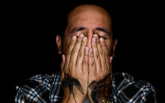 man covering his eyes