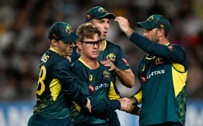 Australian bowler Adam Zampa is congratulated by team mates after taking the wicket of Glenn Phillips during the second T20 Chappell-Hadlee cricket international between Australia and New Zealand at Eden Park in Auckland, Friday Feb. 23, 2024. (Andrew Cornaga/Photosport)