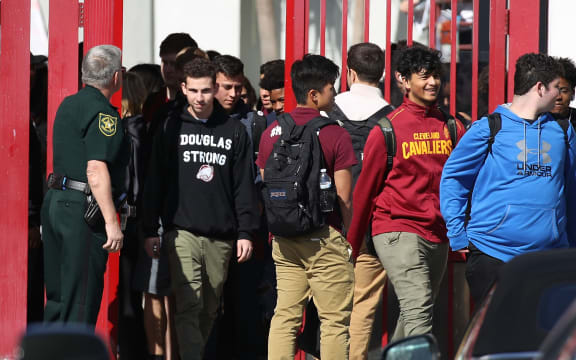 Students from Marjory Stoneman Douglas High School walk out of school to honor the memories of 17 classmates and teachers that were killed during a mass shooting at the school on March 14, 2018 in Parkland, Florida.