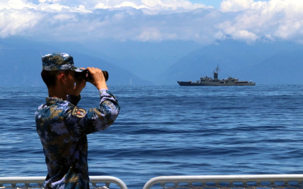 A soldier looks through binoculars during combat exercises and training of the navy of the Eastern Theater Command of the Chinese People's Liberation Army (PLA) in the waters around the Taiwan Island, 5 August, 2022. T