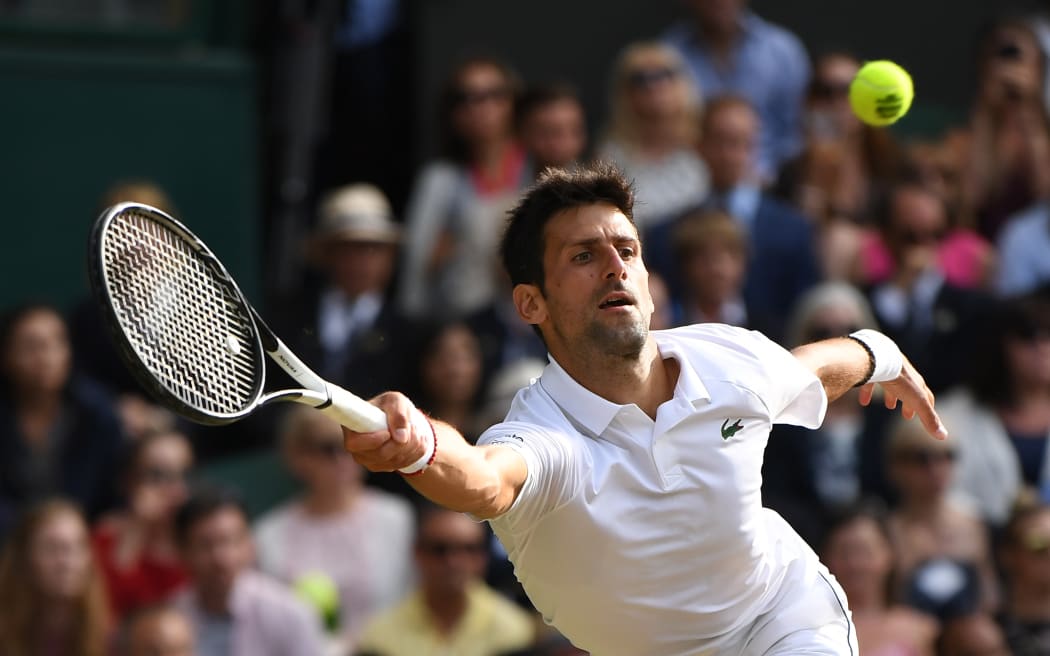 Serbia's Novak Djokovic returns against Switzerland's Roger Federer in the Wimbledon men's final.