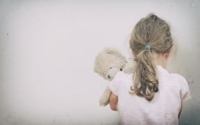 Little girl crying in the corner. Domestic violence concept.