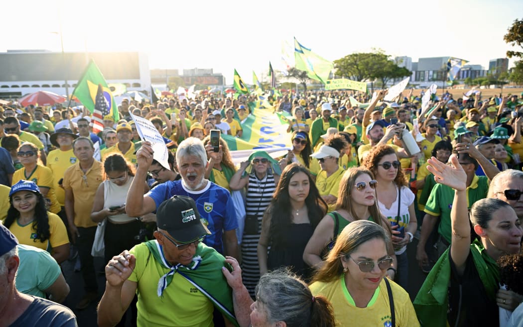 Supporters of former Brazilian President Jair Bolsonaro take part in a march calling for amnesty for those convicted of attempting a coup d'état in Brasilia on October 7, 2025. (Photo by Evaristo Sa / AFP)