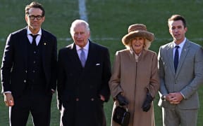 Britain's King Charles III and Britain's Camilla, Queen Consort pose for a photograph with Wrexham AFC Co-Chairman, US actor Ryan Reynolds and US actor Rob McElhenney during their visit to Wrexham Association Football Club in north Wales.
