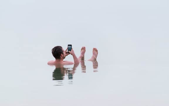 man on phone in sea