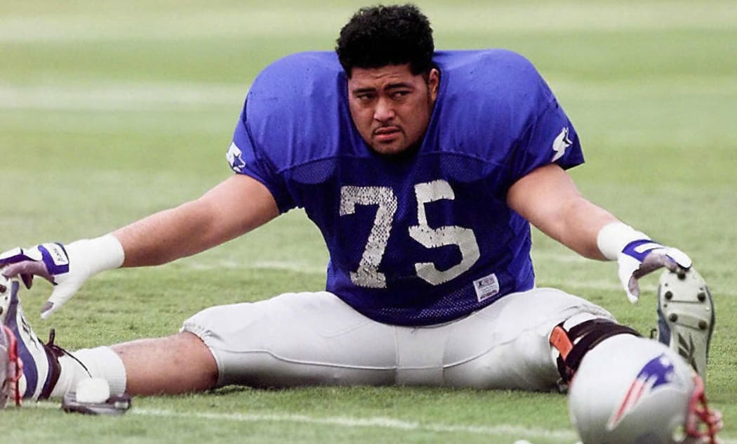 Pio Sagapolutele stretches before an NFL  game in 1997.