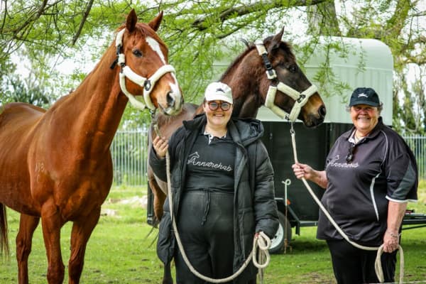 Anna and Maria Baigent hold on to the reins of two horses from AnnaRehab equine assisted learning centre.