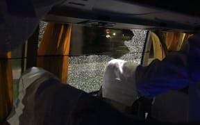 Australian team bus has window smashed by rock.