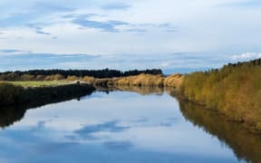 Looking up stream of the wide and still Manawatū river.