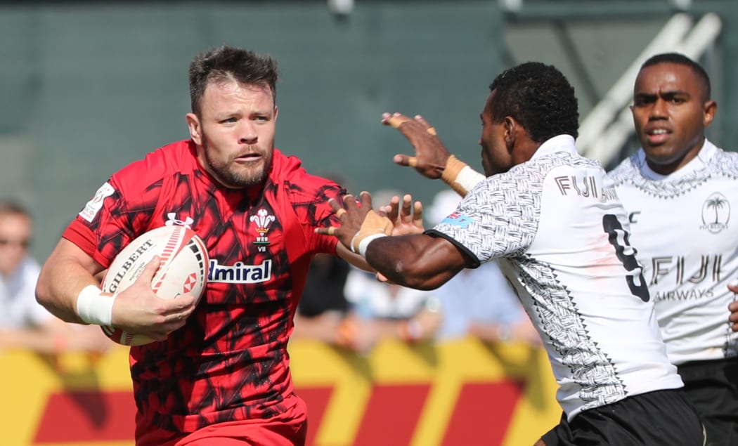 Jerry Tuwai of Fiji (R) is tackled by Wales' Adam Thomas (L) during a match between Fiji and Wales in the Men's Sevens World Rugby Dubai Series on December 1, 2017 in the Gulf emirate of Dubai. / AFP PHOTO / KARIM SAHIB