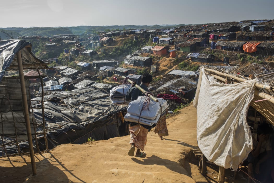 Burmapara camp: Mohhamad Ali (26) carrying relief items; tarpaulin, rope, dry foods and blankets for his family.