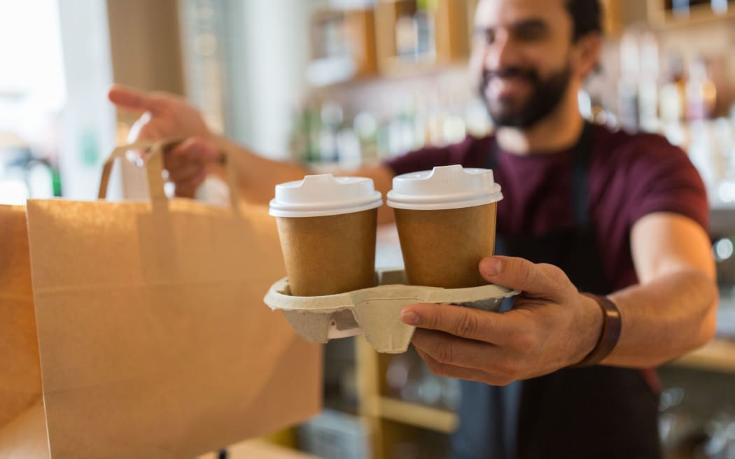 small business, people and service concept - man or bartender serving customer at coffee shop