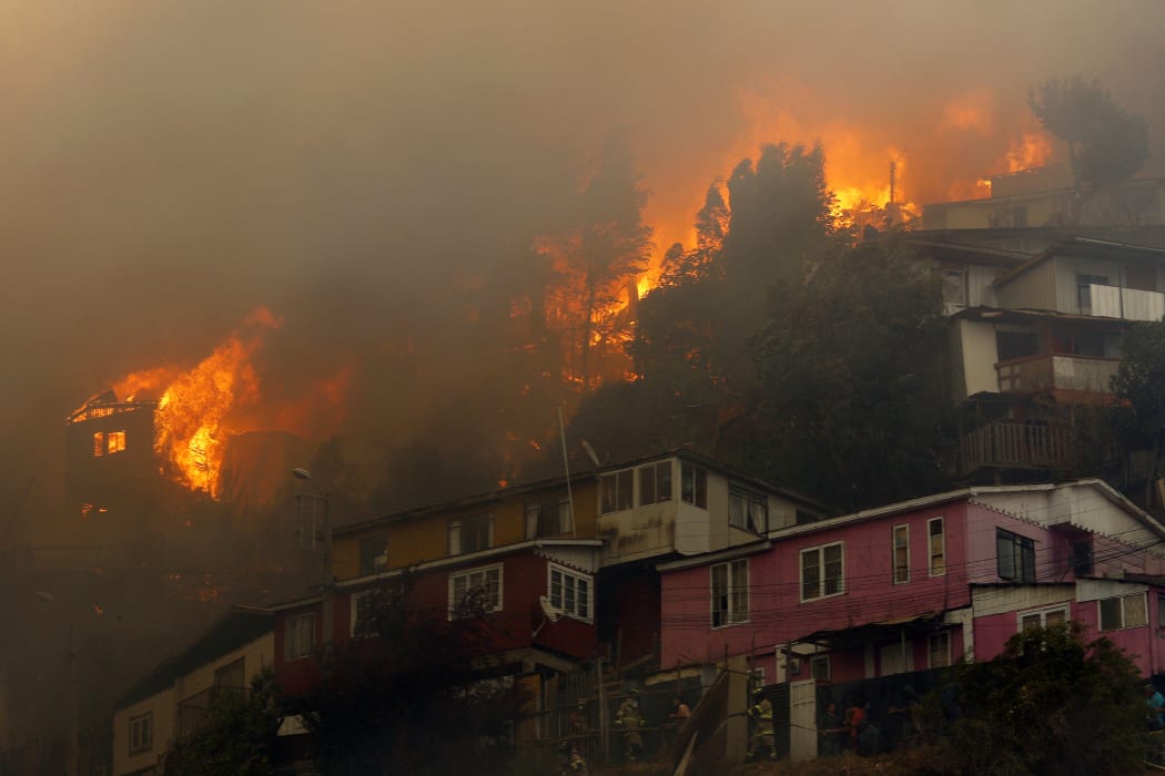Houses burn during a forest fire at the Rocuant hill in Valparaiso, Chile, on 24 December, 2019.