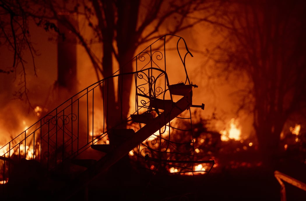 What's left of a staircase stands amidst a smoldering home as the Camp fire tears through Paradise, north of Sacramento, California.