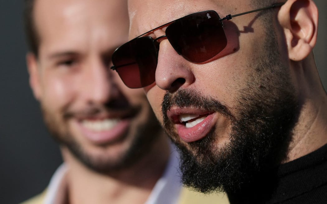 Andrew Tate talks to the media alongside his brother after exiting a courthouse in Bucharest, Romania, on January 9.