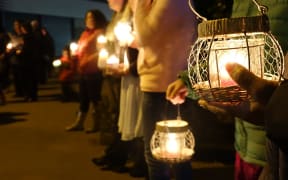 A candle-lit vigil for the victims of Monday's shootings.