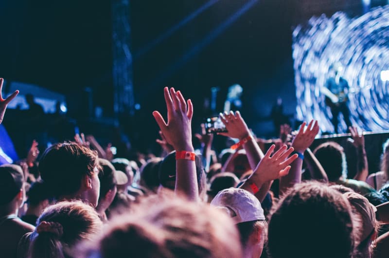 People waving their hands in the air at a music festival.