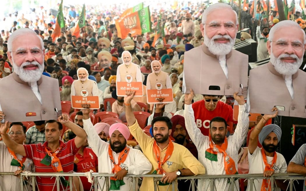 Supporters of the ruling Bharatiya Janta Party (BJP) holding cut-outs of India's Prime Minister and their leader, Narendra Modi shout slogans during an election campaign rally of their president and election candidate Jagat Prakash Nadda (not pictured), in Amritsar on May 30, 2024 ahead of the seventh and final phase of voting in India's general election. (Photo by Narinder NANU / AFP)
