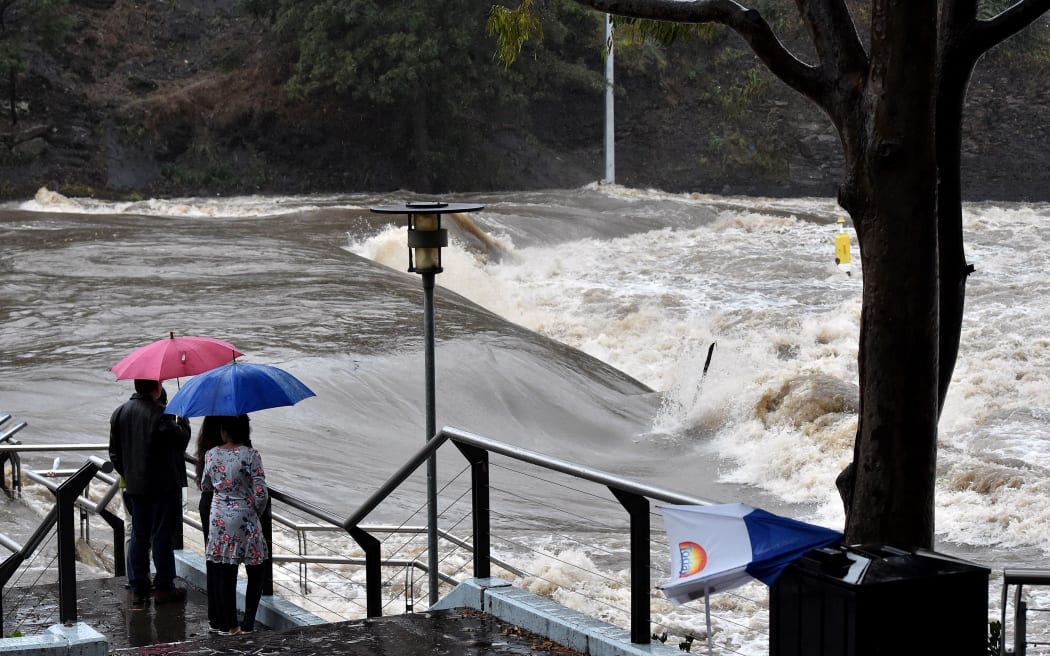 Residents watch the overflowing Parramatta river that submerged a ferry terminal in Sydney.