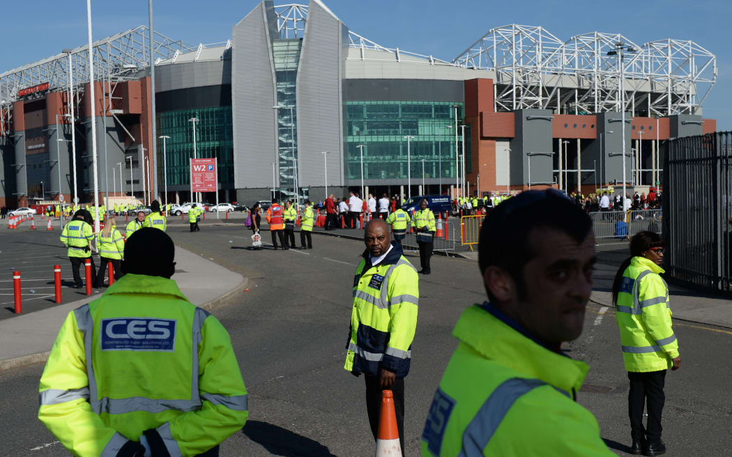 Event staff stand outside the evacuated Old Trafford stadium in Manchester, England on May 15, 2016.
