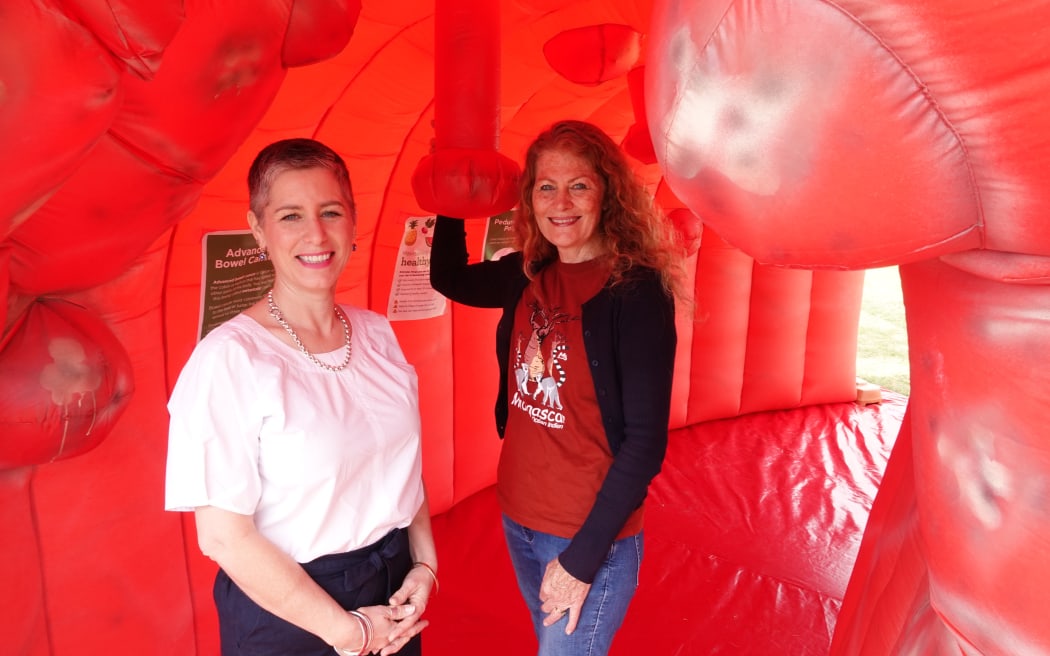 Health NZ general manager of surgical services for Northland, Katy Wilkinson, and Juliana Williams inside a giant inflatable bowel. Photo: RNZ/Peter de Graaf
