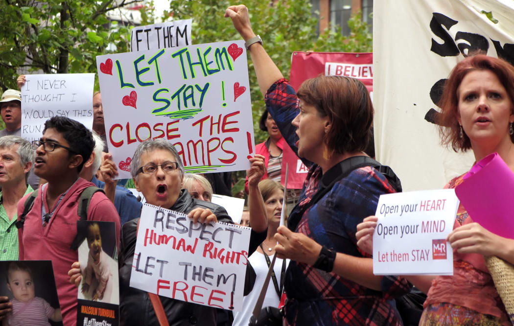 People hold up placards at a protest outside an immigration office in Sydney on 4 February 2016.