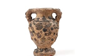 Clay vase decorated with badges made on Gallipoli, 1915 and held at the Auckland War Memorial Museum