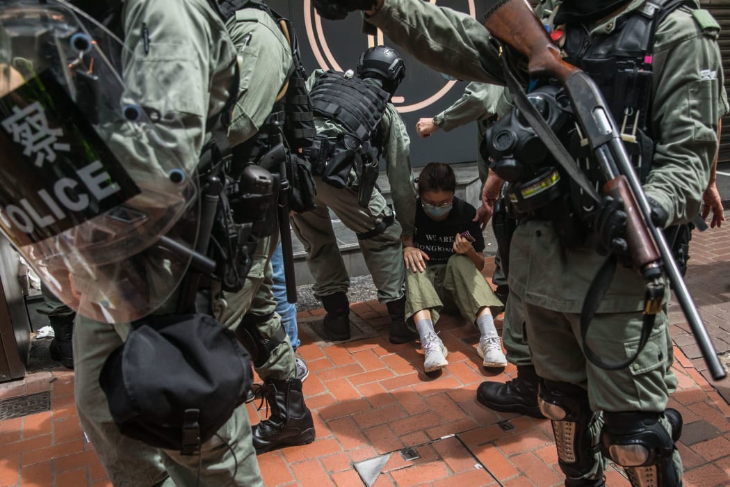 Riot police detain a woman as they clear protesters taking part in a rally against a new national security law in Hong Kong on July 1, 2020, on the 23rd anniversary of the city's handover from Britain to China.