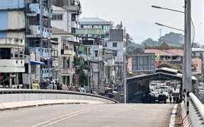A Myanmar flag flutters over a border control building on the Myanmar side of the Thailand-Myanmar Friendship bridge, as seen from Thailand's Mae Sot district on 12 April, 2024.