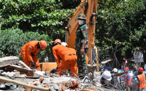 Members of an Indonesian search and rescue team look for victims of the recent quake on Lombok island.
