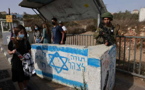 An Israeli soldier on guard at a bus station near the Jewish settlement of Ariel in Palestinian West Bank.