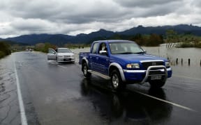 A car is dragged out of floodwaters in the Coromandel.