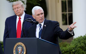 President Donald Trump listens as Vice president Mike Pence answers questions during the daily briefing of the coronavirus task force in the Rose Garden of the White House on April 27, 2020 in Washington, DC.