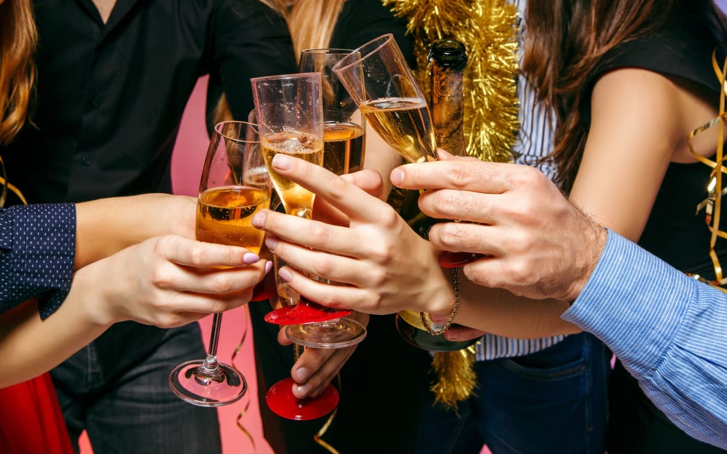 Many young women and men drinking at christmas party on white studio background