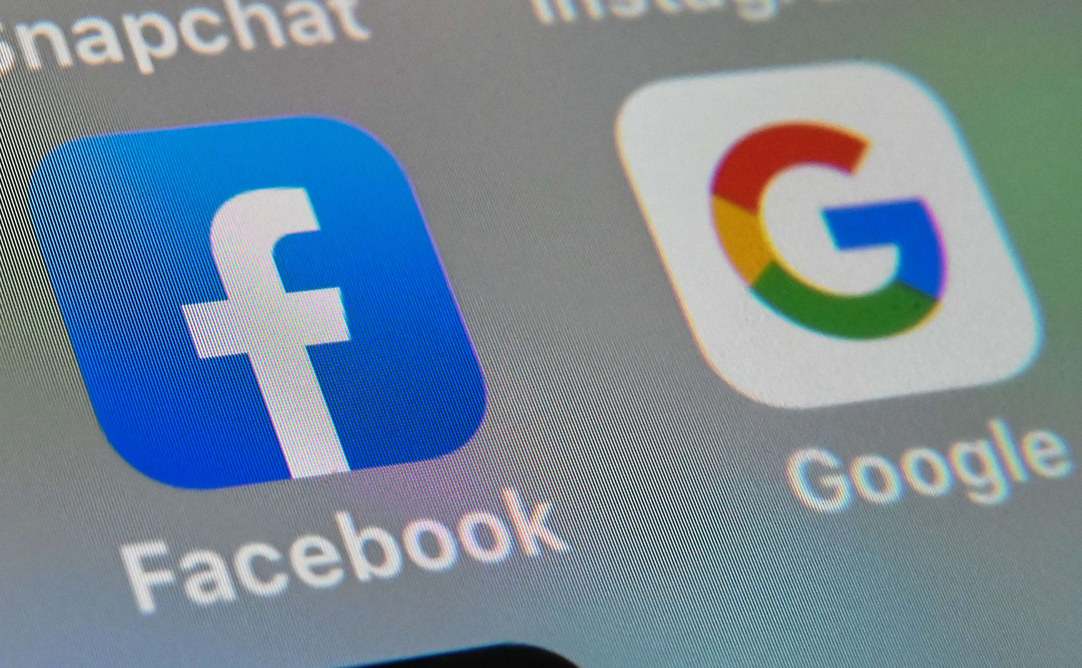 A picture taken on October 1, 2019 in Lille shows the logos of mobile apps Facebook and Google displayed on a tablet. (Photo by DENIS CHARLET / AFP)