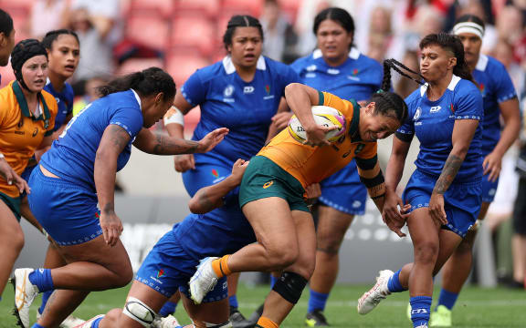 Australia's center Cecilia Smith (C) runs with the ball during the Women’s Rugby World Cup pool A match between Australia and Samoa at Salford Community Stadium in Manchester, northwest England, on August 23, 2025. (Photo by Adrian Dennis / AFP)