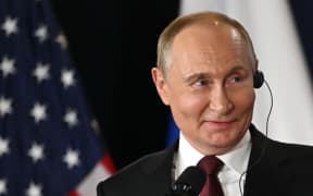 Russian President Vladimir Putin smiles during a joint press conference with US President Donald Trump (out of frame) after participating in a US-Russia summit on Ukraine at Joint Base Elmendorf-Richardson in Anchorage, Alaska, on August 15, 2025. (Photo by ANDREW CABALLERO-REYNOLDS / AFP)
