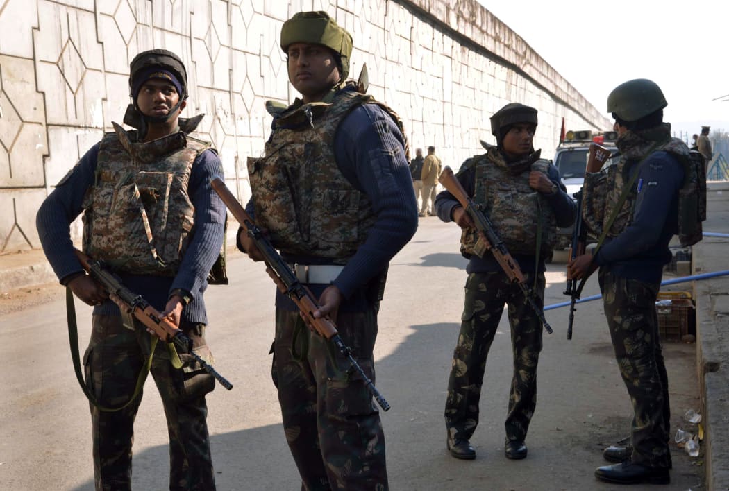 Indian security personnel stand alert on a road leading to an airforce base in Pathankot